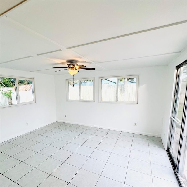 empty room with ceiling fan and light tile patterned floors