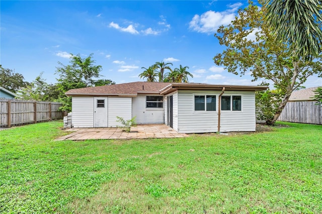 rear view of house with a patio area and a yard