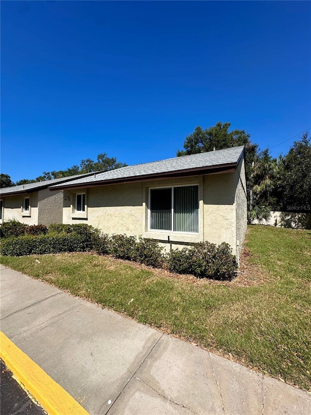 4215 E Bay Dr Unit 1013B, Clearwater, FL 33764 - view of side of home with stucco siding and a yard