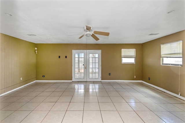 unfurnished room featuring ceiling fan, light tile patterned floors, a wealth of natural light, and french doors