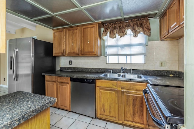 kitchen featuring tasteful backsplash, sink, light tile patterned floors, and stainless steel appliances