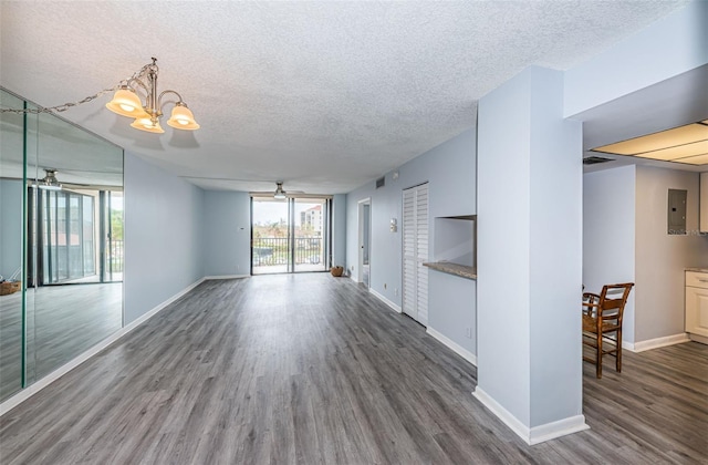 unfurnished living room featuring dark hardwood / wood-style flooring, electric panel, a textured ceiling, and ceiling fan with notable chandelier