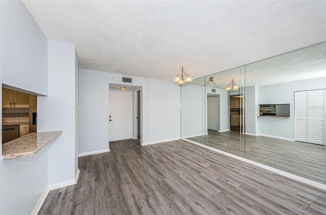 unfurnished living room with hardwood / wood-style flooring and a textured ceiling