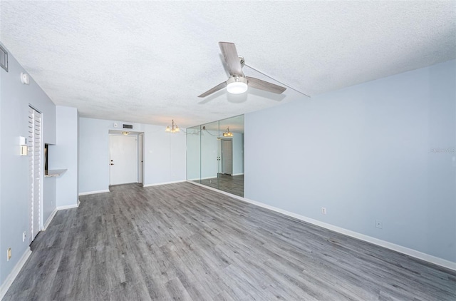 unfurnished room with hardwood / wood-style floors, ceiling fan, and a textured ceiling