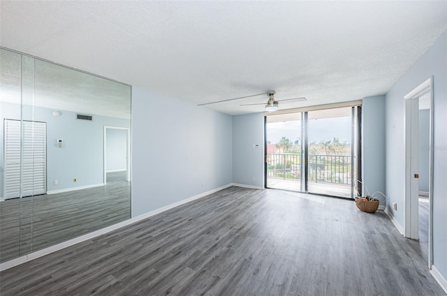 unfurnished room featuring a textured ceiling, dark hardwood / wood-style flooring, and ceiling fan