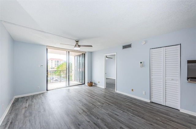 unfurnished room with a textured ceiling, dark hardwood / wood-style flooring, and ceiling fan