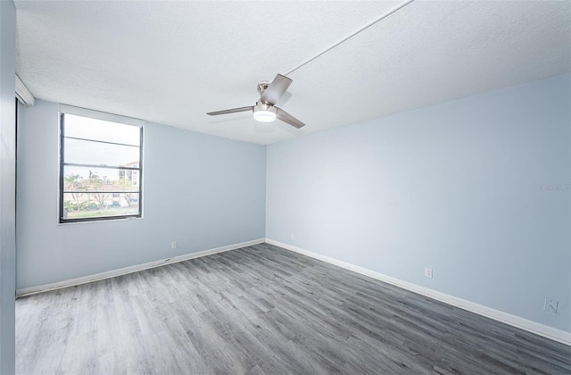 unfurnished room with hardwood / wood-style flooring, ceiling fan, and a textured ceiling