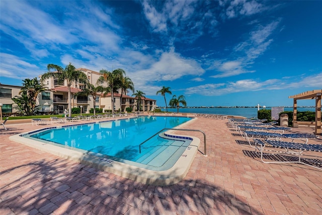 view of pool featuring a water view and a patio area