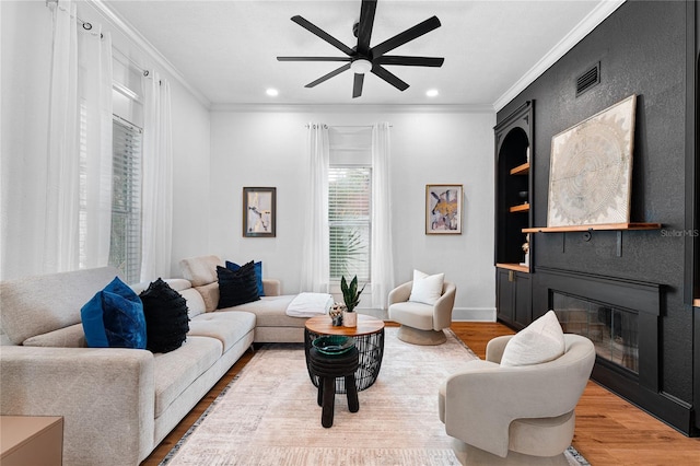 living room featuring hardwood / wood-style flooring, ceiling fan, and ornamental molding