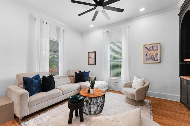 living room featuring ornamental molding, ceiling fan, and light hardwood / wood-style floors