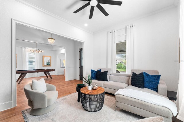 living room with a wealth of natural light, wood finished floors, and ornamental molding