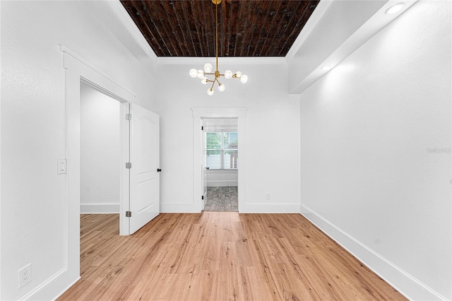 unfurnished dining area with light wood-type flooring, an inviting chandelier, wooden ceiling, and crown molding