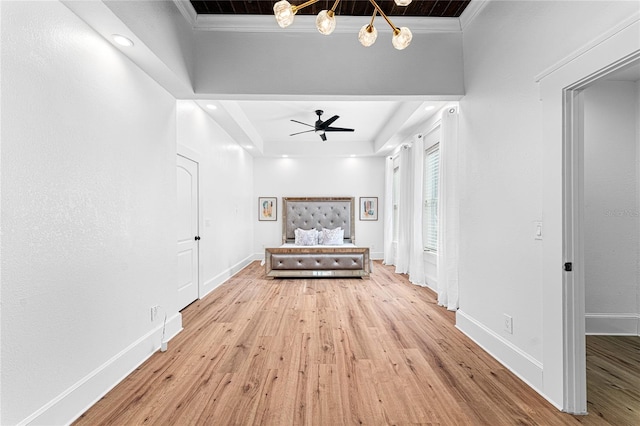 hallway featuring ornamental molding, a tray ceiling, and light hardwood / wood-style floors