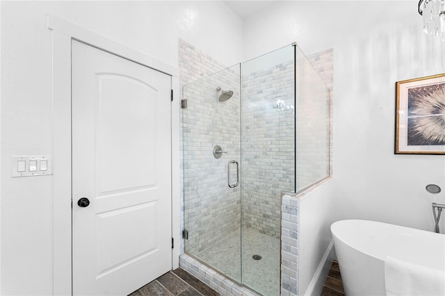 full bath with wood finished floors, a shower stall, and a freestanding tub