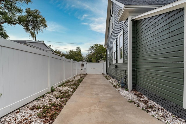 view of home's exterior featuring roof with shingles and fence