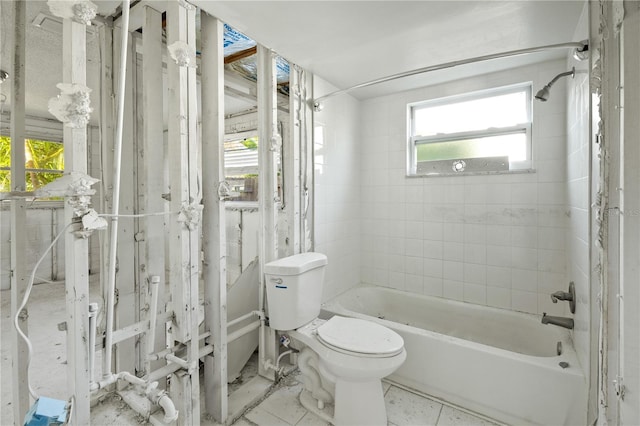 bathroom with toilet and tiled shower / bath