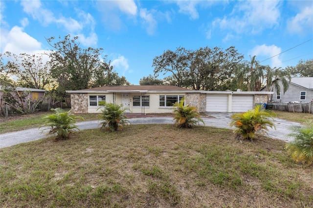 ranch-style house featuring a garage and a front lawn