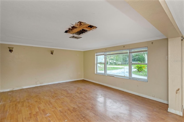 spare room with light wood-type flooring and crown molding