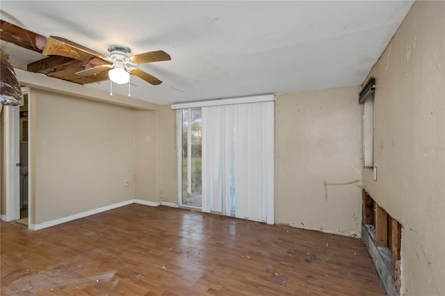 empty room with dark hardwood / wood-style flooring and ceiling fan