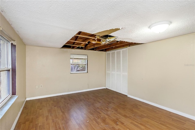 empty room featuring a textured ceiling and dark wood-type flooring