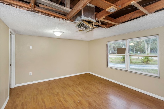 spare room with hardwood / wood-style floors and a textured ceiling