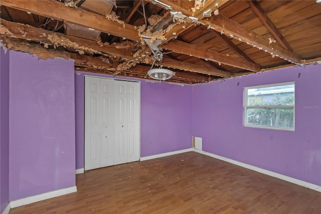 unfurnished bedroom with hardwood / wood-style flooring, lofted ceiling with beams, and wood ceiling