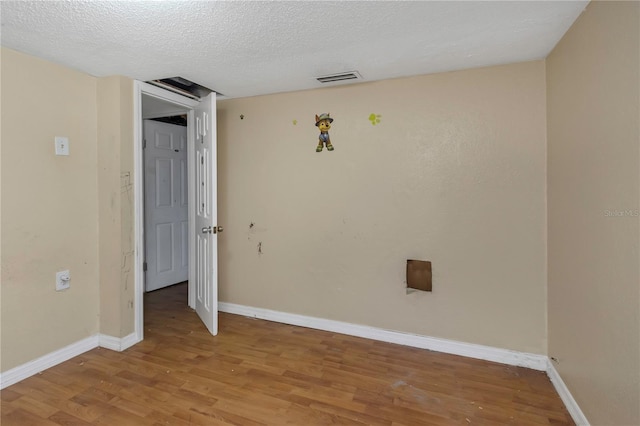 spare room with light hardwood / wood-style floors and a textured ceiling