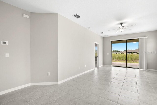 empty room with ceiling fan and light tile patterned flooring