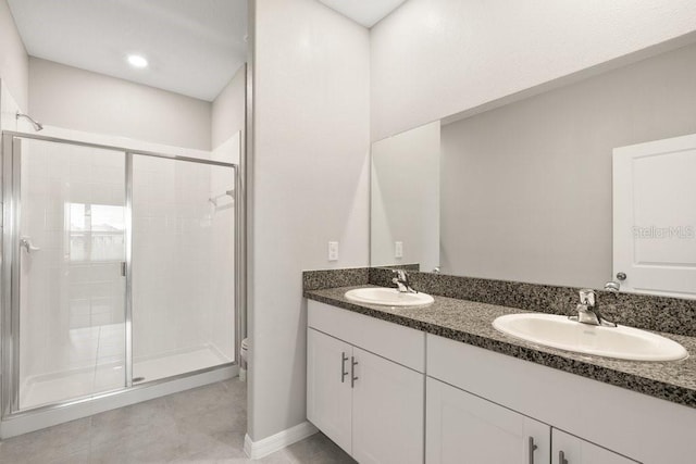 bathroom featuring a shower with shower door, vanity, and toilet