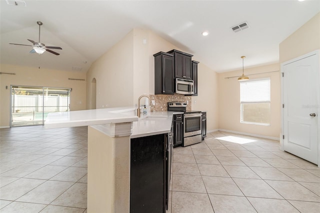 kitchen with vaulted ceiling, ceiling fan, appliances with stainless steel finishes, tasteful backsplash, and light tile patterned flooring