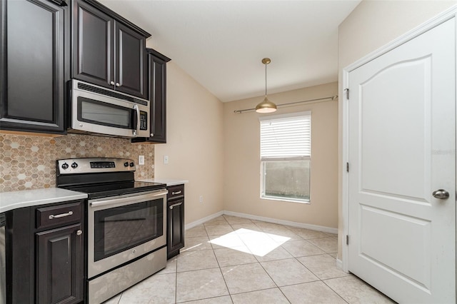 kitchen featuring decorative backsplash, light tile patterned flooring, stainless steel appliances, and hanging light fixtures