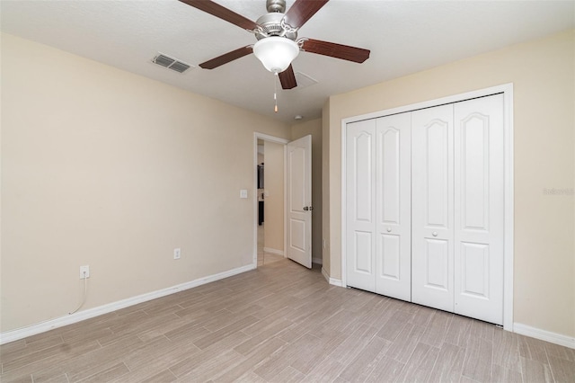 unfurnished bedroom with light hardwood / wood-style flooring, a closet, and ceiling fan