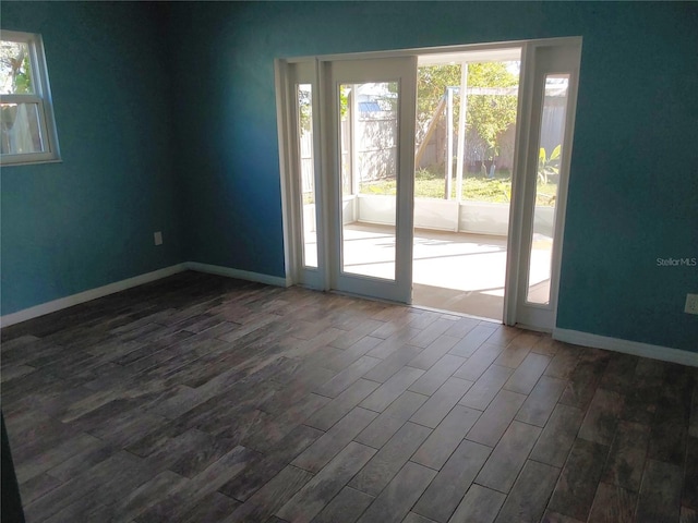 empty room with dark wood-type flooring and a healthy amount of sunlight