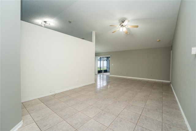 unfurnished room featuring light tile patterned flooring, lofted ceiling, a textured ceiling, and ceiling fan