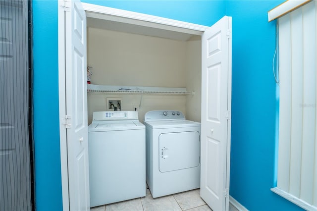 clothes washing area featuring washing machine and dryer and light tile patterned flooring