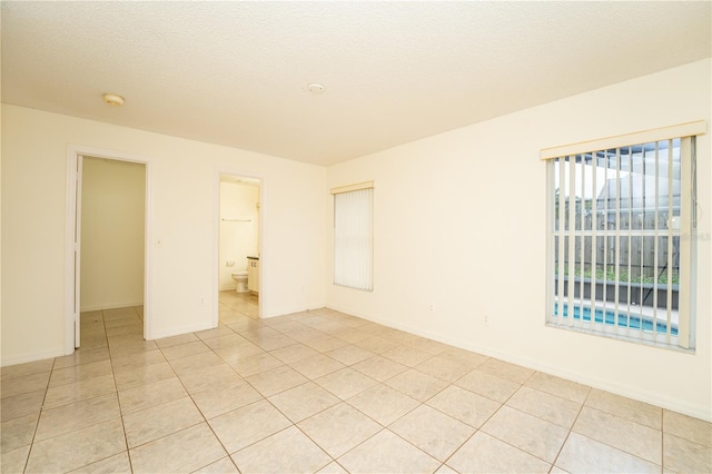 tiled spare room featuring a textured ceiling