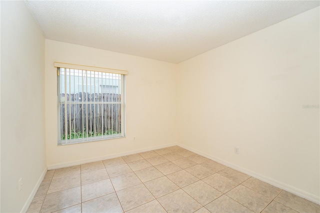 tiled empty room with a textured ceiling