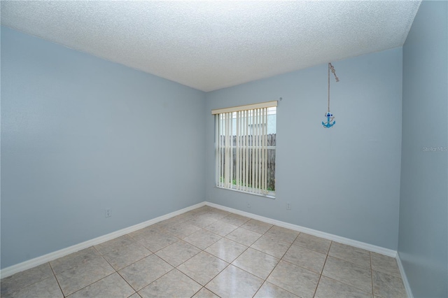 tiled spare room with a textured ceiling