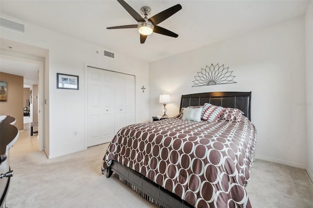 bedroom with light carpet, ceiling fan, and a closet