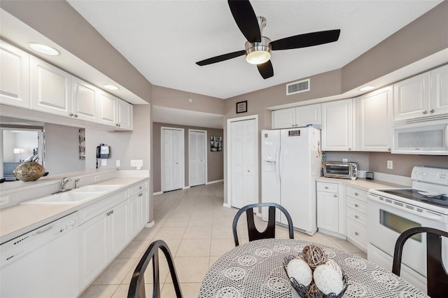 kitchen with light tile patterned floors, sink, white cabinets, white appliances, and ceiling fan