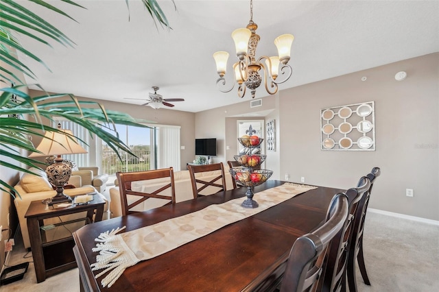 carpeted dining area featuring ceiling fan with notable chandelier