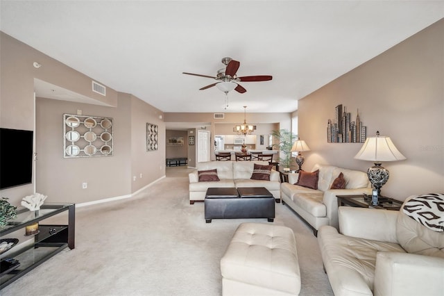 living room with light colored carpet and ceiling fan with notable chandelier