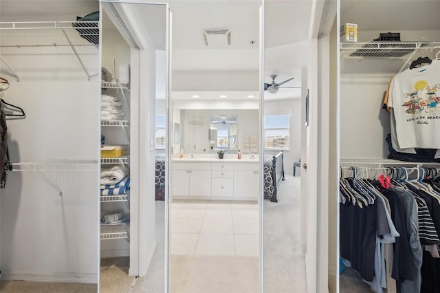 walk in closet featuring ceiling fan, light tile patterned floors, and sink