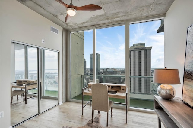 interior space featuring expansive windows, light wood-type flooring, and a wealth of natural light