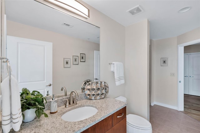 bathroom featuring vanity, tile patterned floors, and toilet