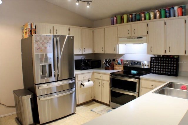 kitchen with stainless steel appliances, lofted ceiling, sink, and light tile patterned floors