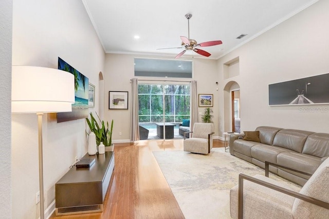 living room featuring ceiling fan, wood-type flooring, and ornamental molding