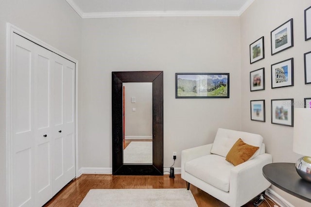 sitting room featuring ornamental molding and wood-type flooring