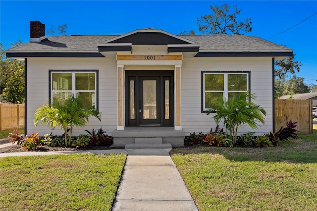 bungalow-style house featuring a front lawn