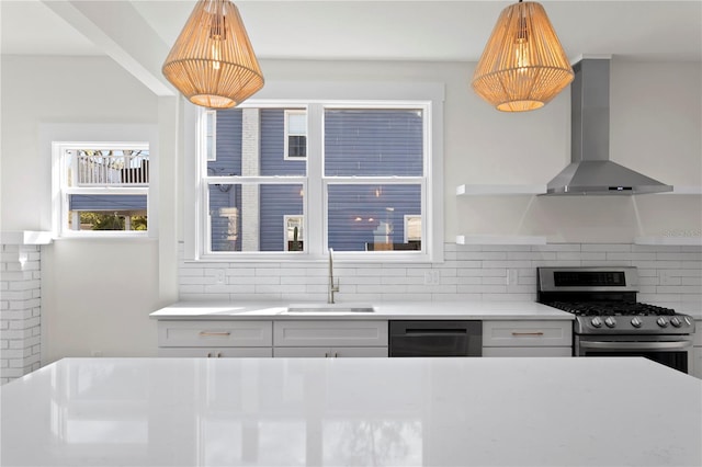 kitchen with stainless steel gas range, decorative backsplash, sink, dishwashing machine, and wall chimney exhaust hood